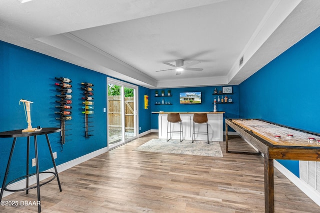 1197 Southfork Ct, Port Orange, FL 32129 - recreation room with a dry bar, a tray ceiling, wood finished floors, a ceiling fan, and crown molding