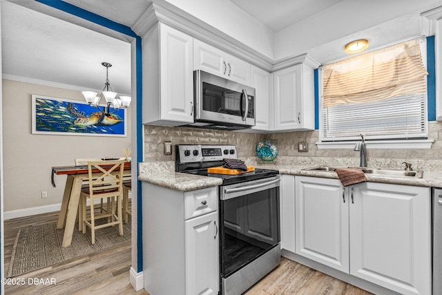 1197 Southfork Ct, Port Orange, FL 32129 - kitchen with appliances with stainless steel finishes, light wood finished floors, tasteful backsplash, white cabinetry, and crown molding