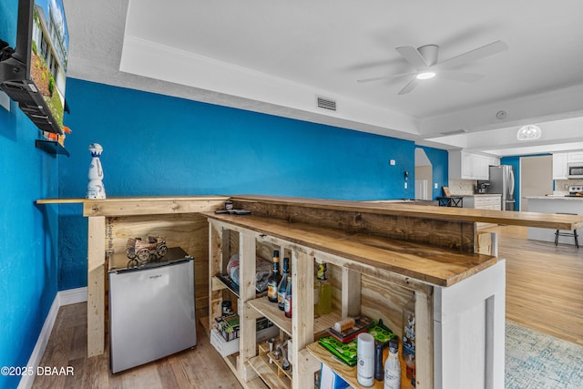 1197 Southfork Ct, Port Orange, FL 32129 - bar with fridge, freestanding refrigerator, wood finished floors, a ceiling fan, and ornamental molding