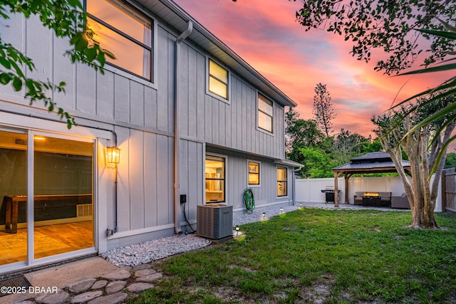 1197 Southfork Ct, Port Orange, FL 32129 - rear view of house featuring a gazebo, an outdoor living space, a fenced backyard, a patio area, and board and batten siding