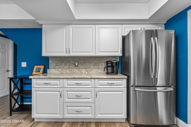1197 Southfork Ct, Port Orange, FL 32129 - kitchen featuring freestanding refrigerator, white cabinets, backsplash, and wood finished floors