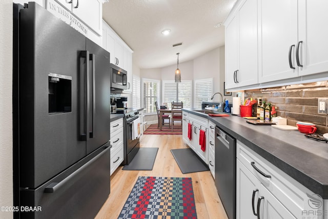 3349 Glenshane Way, Ormond Beach, FL 32174 - kitchen featuring stainless steel appliances, dark countertops, decorative backsplash, white cabinets, and lofted ceiling