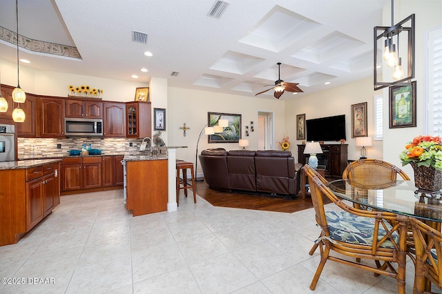 1491 Hohe Ln, Ormond Beach, FL 32174 - kitchen with appliances with stainless steel finishes, coffered ceiling, decorative backsplash, light stone counters, and recessed lighting