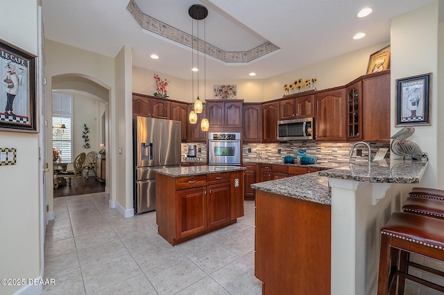 1491 Hohe Ln, Ormond Beach, FL 32174 - kitchen with stainless steel appliances, arched walkways, dark stone countertops, backsplash, and recessed lighting