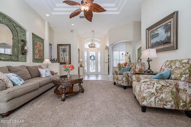 1491 Hohe Ln, Ormond Beach, FL 32174 - tiled living area featuring ornate columns, a ceiling fan, carpet, a chandelier, and a raised ceiling