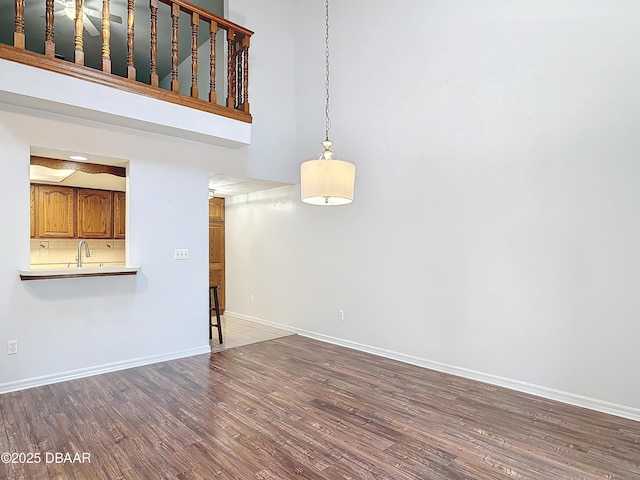 unfurnished living room featuring wood finished floors and baseboards