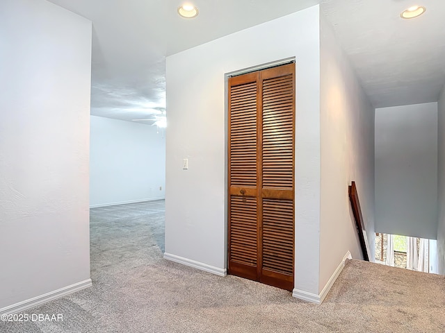 corridor featuring recessed lighting, baseboards, and light colored carpet