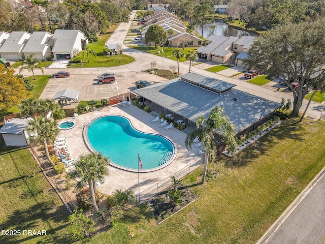 pool with a residential view, a water view, a patio, and fence