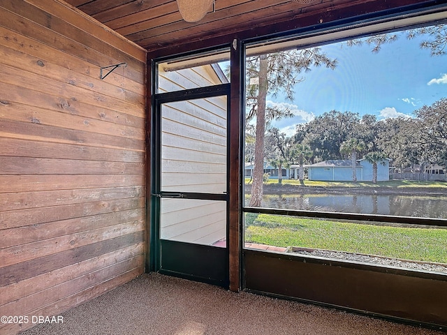 unfurnished sunroom featuring wood ceiling and a water view