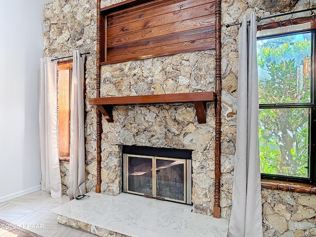 room details featuring a stone fireplace and baseboards