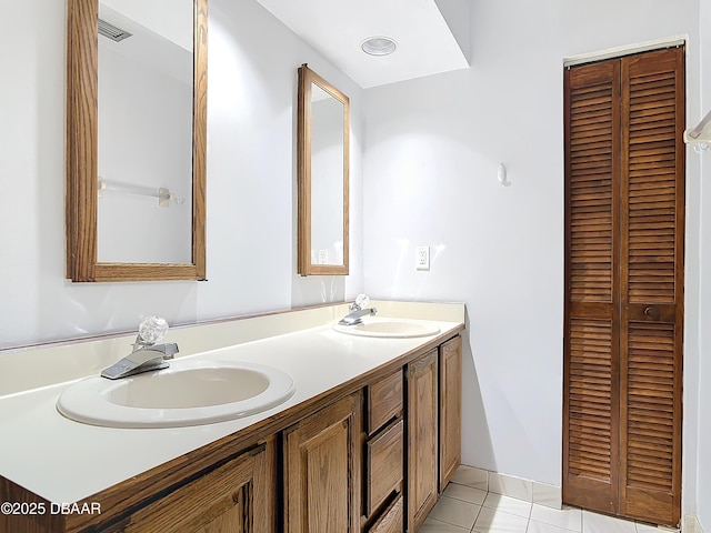 bathroom featuring a sink, double vanity, visible vents, and a closet