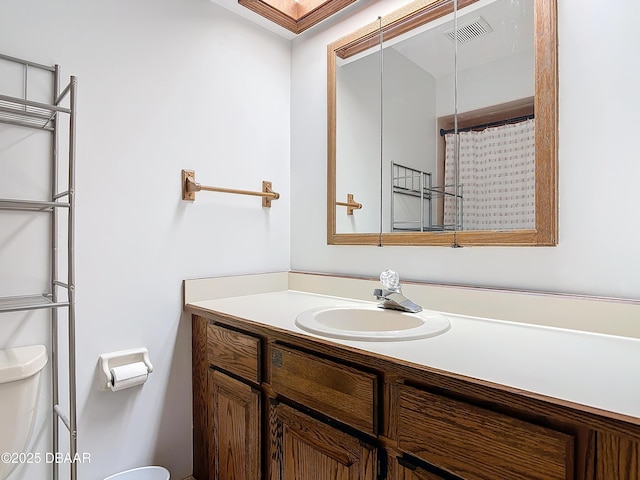 full bath with visible vents, vanity, and toilet