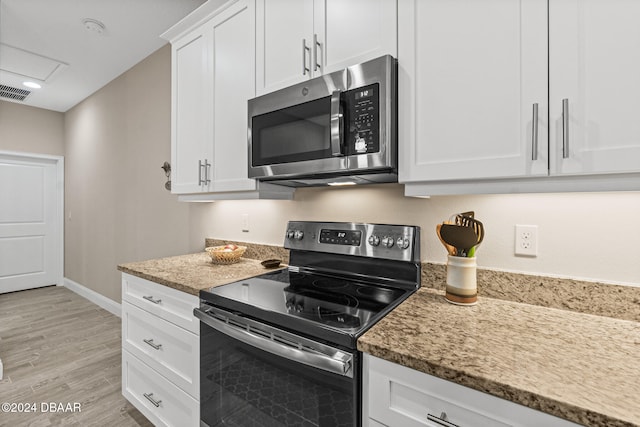 kitchen featuring white cabinetry, stainless steel appliances, light stone counters, and light hardwood / wood-style flooring