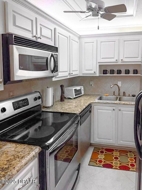 3043 S Atlantic Ave Unit 204, Daytona Beach Shores, FL 32118 - kitchen with stainless steel appliances, a sink, white cabinetry, ceiling fan, and light tile patterned flooring