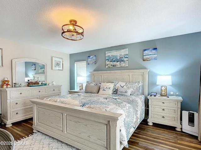 bedroom with a textured ceiling and dark hardwood / wood-style flooring