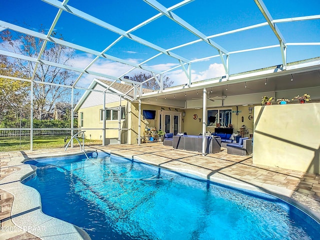 view of pool with a patio, ceiling fan, glass enclosure, and an outdoor living space