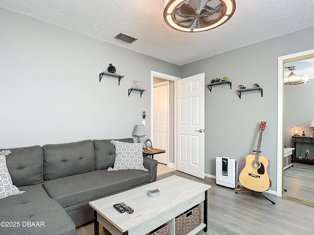 living room featuring a textured ceiling and light hardwood / wood-style flooring