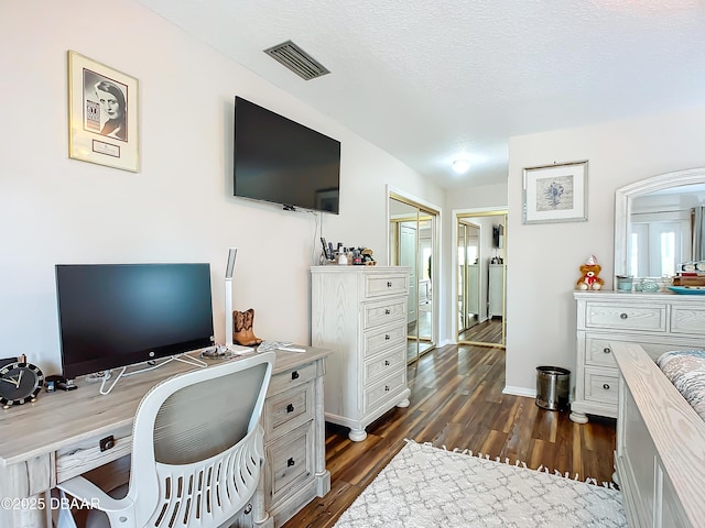 home office featuring a textured ceiling and dark hardwood / wood-style floors