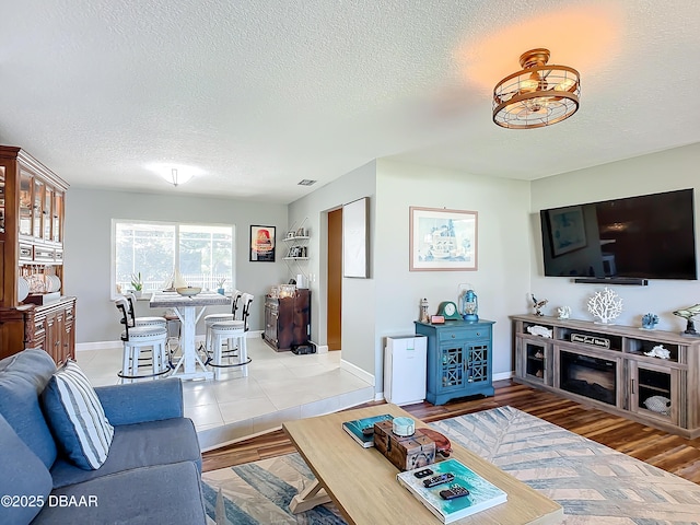 living room with a textured ceiling and light hardwood / wood-style floors