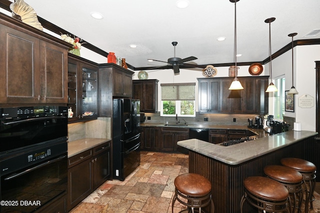 kitchen with sink, decorative light fixtures, ornamental molding, dark brown cabinetry, and a breakfast bar