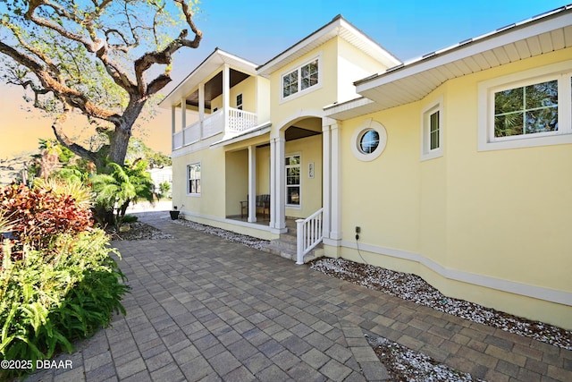 rear view of property featuring a patio area and a balcony