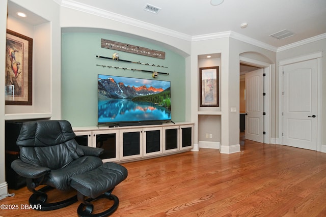 sitting room with light hardwood / wood-style floors and crown molding