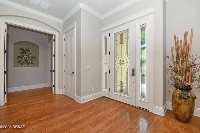 foyer featuring ornamental molding and light hardwood / wood-style flooring