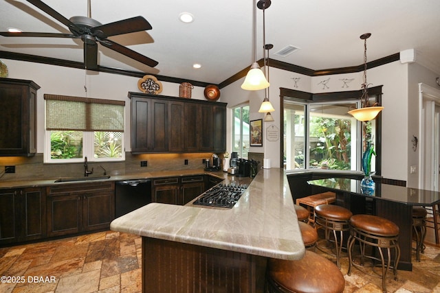 kitchen featuring black appliances, backsplash, a breakfast bar area, ornamental molding, and sink