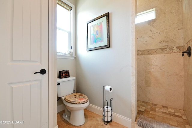 bathroom featuring a healthy amount of sunlight, tiled shower, and toilet