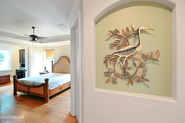 bedroom featuring ornamental molding, ceiling fan, and hardwood / wood-style floors