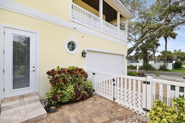 doorway to property with a balcony and a garage