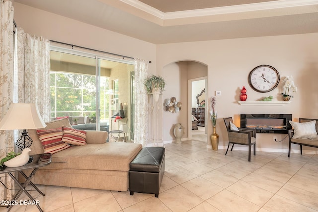 3418 Leonardo Ln, New Smyrna Beach, FL 32168 - living room featuring arched walkways, light tile patterned floors, crown molding, and a tray ceiling