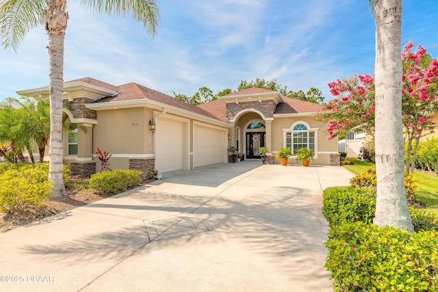 3418 Leonardo Ln, New Smyrna Beach, FL 32168 - mediterranean / spanish-style home featuring stone siding, stucco siding, an attached garage, and concrete driveway
