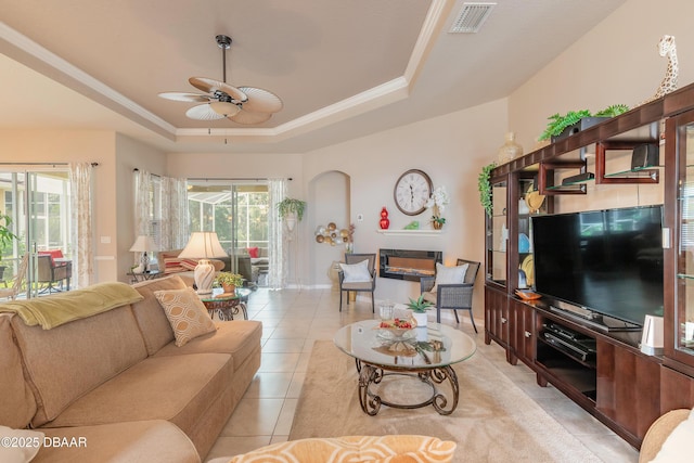 3418 Leonardo Ln, New Smyrna Beach, FL 32168 - living room featuring a raised ceiling, ceiling fan, light tile patterned flooring, plenty of natural light, and ornamental molding
