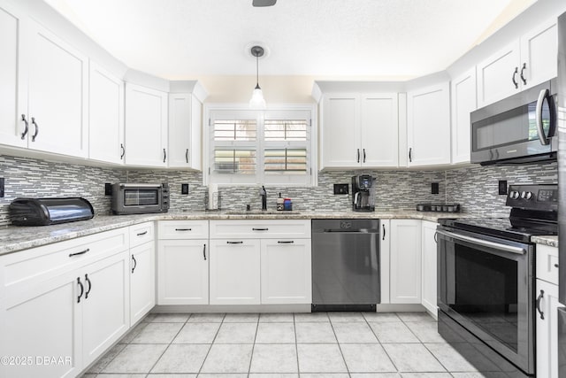34 Old Macon Dr, Ormond Beach, FL 32174 - kitchen with tasteful backsplash, stainless steel appliances, light tile patterned floors, and a sink