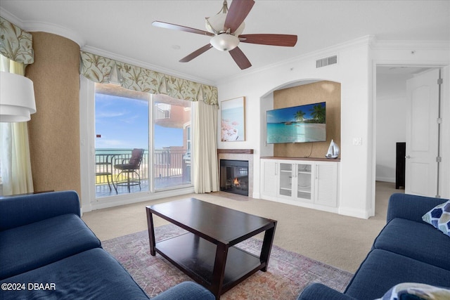 living room with ceiling fan, light colored carpet, and ornamental molding