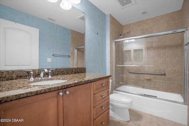 full bathroom featuring toilet, vanity, bath / shower combo with glass door, and tile patterned flooring