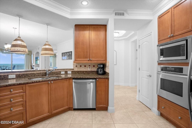 kitchen featuring dark stone countertops, crown molding, and stainless steel appliances