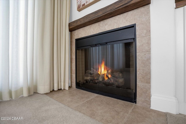 interior details with a tiled fireplace and carpet floors