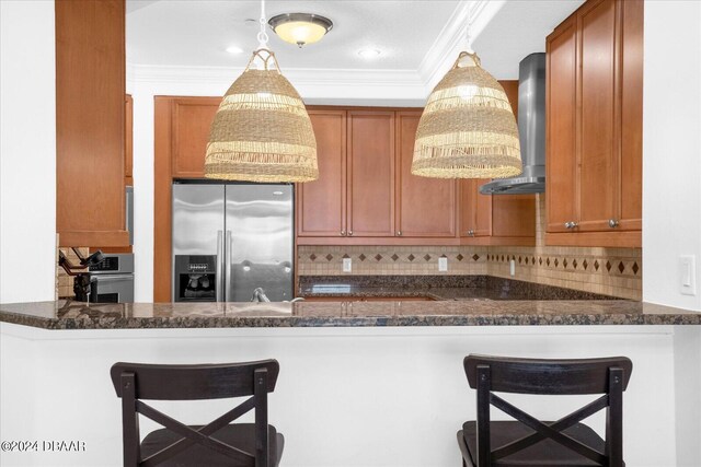 kitchen featuring stainless steel appliances, a kitchen bar, dark stone counters, and decorative light fixtures