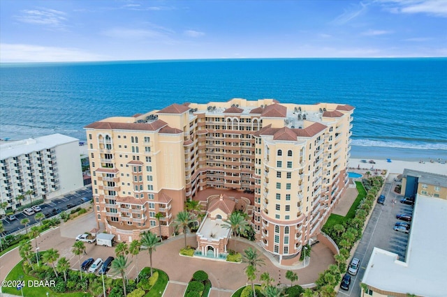 drone / aerial view featuring a beach view and a water view