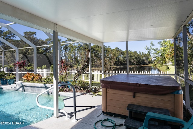 exterior space with a patio, a water view, a hot tub, and glass enclosure