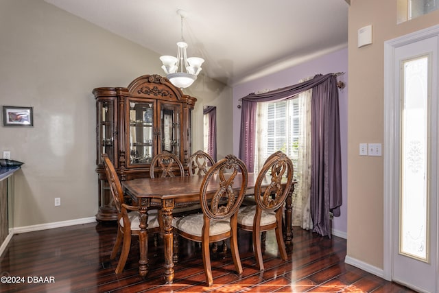 dining area featuring a notable chandelier, dark hardwood / wood-style floors, and vaulted ceiling