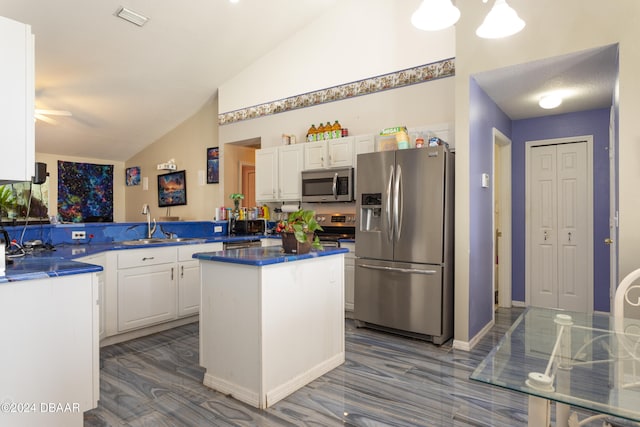 kitchen featuring kitchen peninsula, white cabinets, vaulted ceiling, and appliances with stainless steel finishes