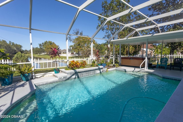 view of swimming pool featuring a patio, a hot tub, and a lanai