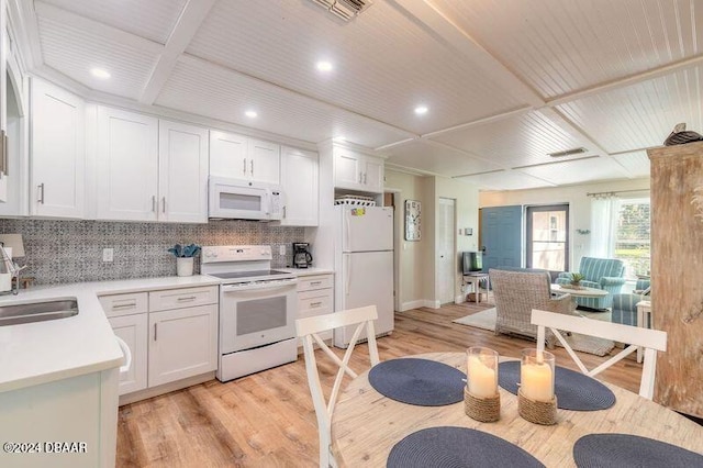 kitchen with white cabinets, white appliances, and light hardwood / wood-style flooring