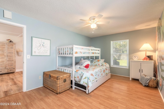 bedroom featuring light wood-type flooring, a textured ceiling, and ceiling fan