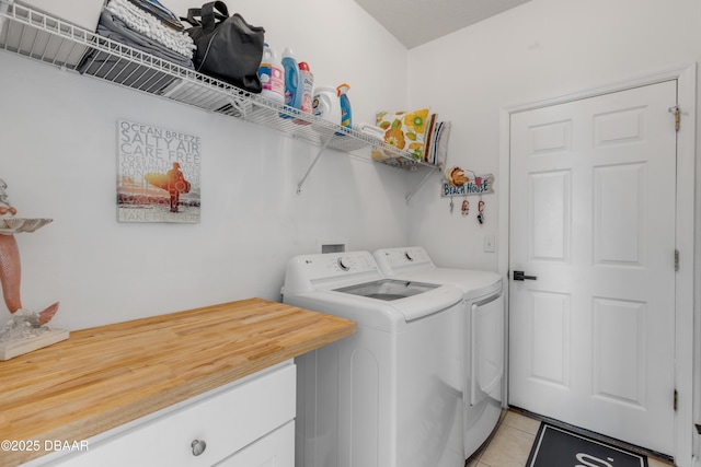 laundry room featuring washer and clothes dryer and light tile patterned flooring