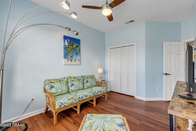 living area featuring dark hardwood / wood-style flooring and ceiling fan