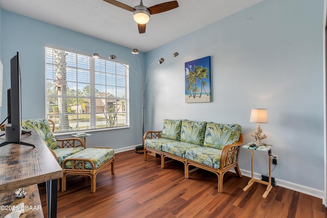 living area featuring ceiling fan and dark hardwood / wood-style flooring